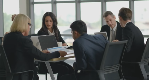 Équipe dirigeante en réunion stratégique autour d’une table, illustrant la réflexion sur la stratégie talents, le leadership et le développement du capital humain à long terme.